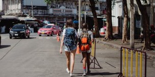 A photo of two individuals walking in the heat of the sun