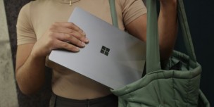 A photo depicting a woman packing up with her Microsoft laptop