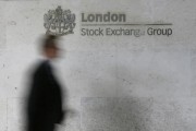 A man walks past the London Stock Exchange in the City of London October 11, 2013. 