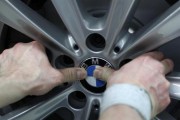 An employee places the company logo on a BMW wheel rim at the production line of the German car manufacturer's plant in the Bavarian city of Dingolfing March 6, 2012. 