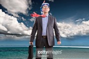 Businessman standing ankle-deep in water, wearing snorkel 
