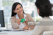 Female doctor giving a health insurance card to a patient 
