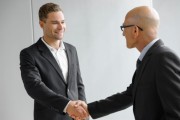 Senior and young businessman shaking hands 