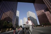 A news vendor walks with a bicycle at the Central Business District in Beijing July 9, 2009.