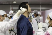 A worker is screened for radiation as he enters the emergency operation center at Tokyo Electric Power Co. (TEPCO)'s tsunami-crippled Fukushima Daiichi nuclear power plant in Fukushima prefecture in t