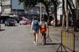 A photo of two individuals walking in the heat of the sun