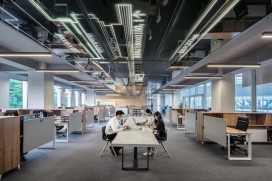 A photo of an office space with few workers 